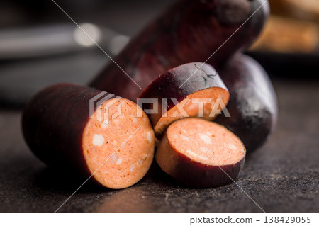 Smoked Sausage With Dark Casing Sliced Closeup on Rustic Surface, Deli Meat Appetizer 138429055
