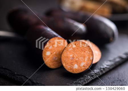 Smoked Sausage With Dark Casing Sliced Closeup on Rustic Surface, Deli Meat Appetizer 138429060