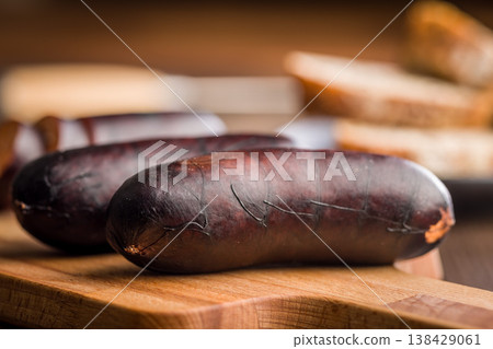 Smoked Blood Sausage (Black Pudding) on Wooden Cutting Board With Bread in Background 138429061