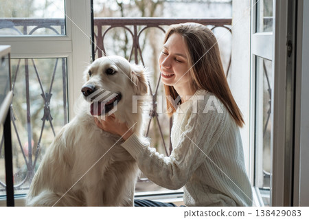 Woman happy petting her golden retriever dog Woman happy petting her golden retriever dog 138429083