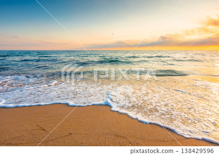 autumn vacation at the sea. beautiful seascape at sunrise. calm waves wash the sandy beach. image with fluffy clouds on the sky above horizon. perfect background for relaxation or ads placement autumn vacation at the sea. beautiful seascape at sunrise. calm waves wash the sandy beach. image with fluffy clouds on the sky above horizon. perfect background for relaxation or ads placement 138429596