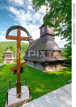 likitsary, ukraine - 02 july 2020: church in traditional orthodox wooden architecture of europe. summer countryside scenery in carpathian mountains near the slovakia border. cloudy sky. vertical view 138429598