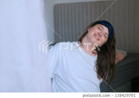 Woman in home clothes sits on bed after waking relaxed and calm with comfortable mattress and pillow for quality sleep and energy morning Woman in home clothes sits on bed after waking relaxed and calm with comfortable mattress and pillow for quality sleep and energy morning 138429701