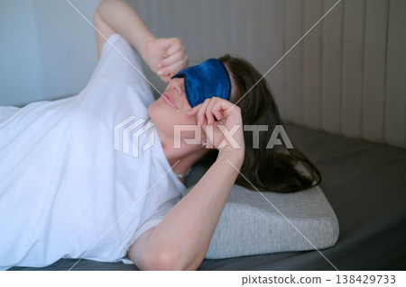 Orthopedic pillow supports neck reducing tension woman resting with sleep mask ensuring full darkness comfort and healthy sleep support Orthopedic pillow supports neck reducing tension woman resting with sleep mask ensuring full darkness comfort and healthy sleep support 138429733