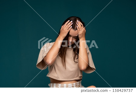 Stressed young woman suffering from headache holding head with hands feeling frustration, mental health issues Stressed young woman suffering from headache holding head with hands feeling frustration, mental health issues 138429737