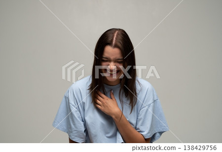 Young woman laughing heartily, experiencing happiness and joy, expressing genuine positive emotions 138429756