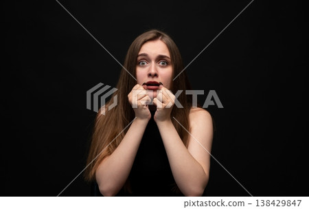 Young woman feeling fear and panic, expressing fright and anxiety with wide eyes and hands clenching face Young woman feeling fear and panic, expressing fright and anxiety with wide eyes and hands clenching face 138429847