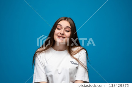 Young woman feeling confused and unsure, expressing uncertainty, doubt, and indecision on a blue background Young woman feeling confused and unsure, expressing uncertainty, doubt, and indecision on a blue background 138429875