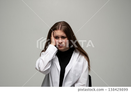 Young woman experiencing severe headache and migraine, showing emotional distress, sadness, and stress 138429899