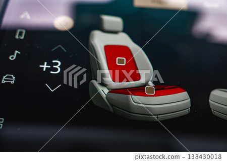 A close up shows a car touchscreen with a seat graphic, red zones for heating or massage, icons for music and settings, value at plus 3, glossy UI, shallow depth of field. A close up shows a car touchscreen with a seat graphic, red zones for heating or massage, icons for music and settings, value at plus 3, glossy UI, shallow depth of field. 138430018