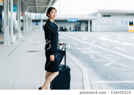 一位女商人正在機場等計程車。 一位女商人正在機場等計程車。 138430228