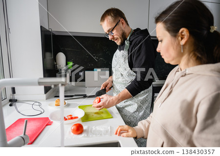 Couple preparing food together in modern kitchen at home Couple preparing food together in modern kitchen at home 138430357