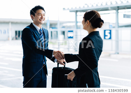 A man and a woman shake hands as a business greeting. (Photo courtesy of Kansai International Airport (KIX)) 138430599