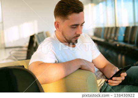 Waiting for a flight in comfort man charging devices in seat using modern solutions for travelers and staying productive on the go 138430922