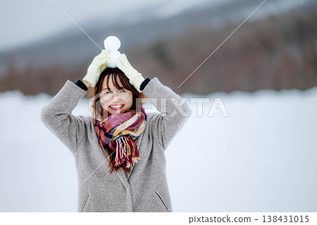 一位年輕女子抱著一個雪人 一位年輕女子抱著一個雪人 138431015