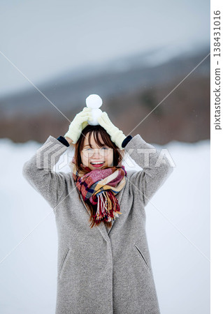 一位年輕女子抱著一個雪人 一位年輕女子抱著一個雪人 138431016