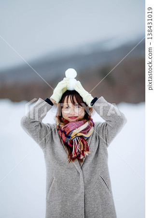 一位年輕女子抱著一個雪人 一位年輕女子抱著一個雪人 138431019