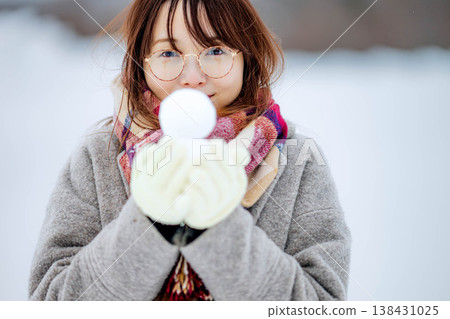 A young woman holding a snowman A young woman holding a snowman 138431025