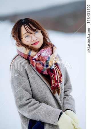 一位穿著外套的年輕女子在雪地裡玩耍 一位穿著外套的年輕女子在雪地裡玩耍 138431302