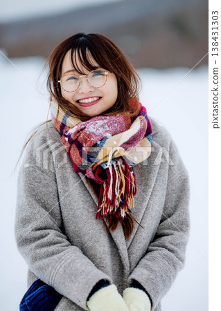 一位穿著外套的年輕女子在雪地裡玩耍 一位穿著外套的年輕女子在雪地裡玩耍 138431303