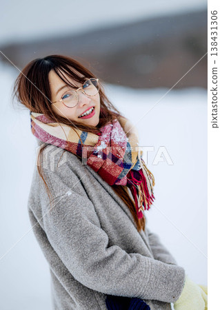 A young woman in a coat enjoying herself in the snow A young woman in a coat enjoying herself in the snow 138431306