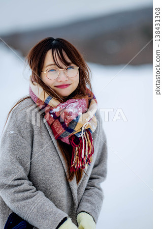 一位穿著外套的年輕女子在雪地裡玩耍 一位穿著外套的年輕女子在雪地裡玩耍 138431308