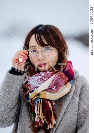 一位穿著外套的年輕女子在雪地裡玩耍 一位穿著外套的年輕女子在雪地裡玩耍 138431324