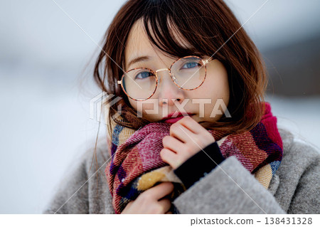 一位穿著外套的年輕女子在雪地裡玩耍 一位穿著外套的年輕女子在雪地裡玩耍 138431328
