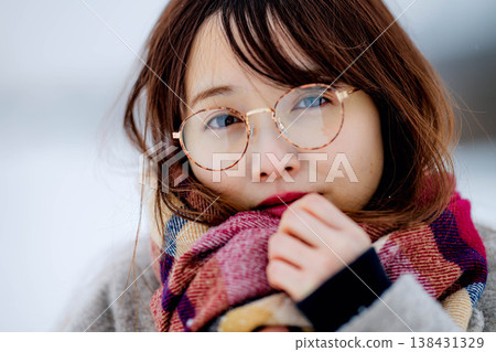 一位穿著外套的年輕女子在雪地裡玩耍 一位穿著外套的年輕女子在雪地裡玩耍 138431329