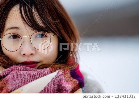 A young woman in a coat enjoying herself in the snow A young woman in a coat enjoying herself in the snow 138431332