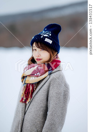 Smiling woman standing on snow 138431517