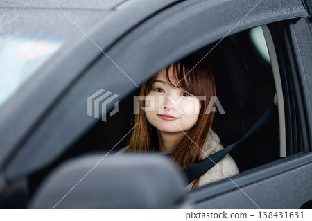 A young woman driving a car in the winter snow. A young woman driving a car in the winter snow. 138431631