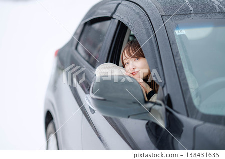一位年輕女子在冬日的雪地裡開車。 一位年輕女子在冬日的雪地裡開車。 138431635