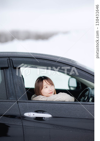 一位年輕女子在冬日的雪地裡開車。 一位年輕女子在冬日的雪地裡開車。 138431646