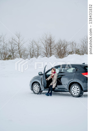 冬日雪地裡,一位年輕女子坐在車裡。 冬日雪地裡,一位年輕女子坐在車裡。 138431832