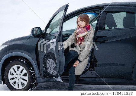 冬日雪地裡，一位年輕女子坐在車裡。 138431837