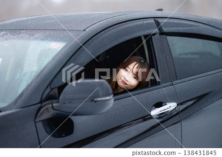 A young woman in a car in the winter snow 138431845