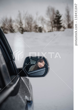 冬日雪地裡,一位年輕女子坐在車裡。 冬日雪地裡,一位年輕女子坐在車裡。 138431847