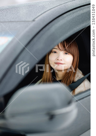 冬日雪地裡,一位年輕女子坐在車裡。 冬日雪地裡,一位年輕女子坐在車裡。 138431849