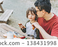 Close-up view of father hugs his school boy son on a family picnic in the mountains. Child kid and his dad taking a rest and enjoying a picnic while hiking in the mountains 138431998