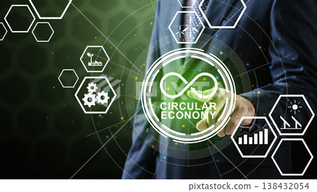 A businessman in a suit touches a glowing Circular Economy interface. The design includes icons for wind energy, solar power, industrial gears, and growth on a dark digital background A businessman in a suit touches a glowing Circular Economy interface. The design includes icons for wind energy, solar power, industrial gears, and growth on a dark digital background 138432054