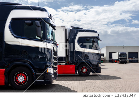 Modern blue cargo truck delivery van parked logistics warehouse center complex building exterior bay. Semi-trailer lorry unload goods distribution blue sky. Cargo storage facility industry building Modern blue cargo truck delivery van parked logistics warehouse center complex building exterior bay. Semi-trailer lorry unload goods distribution blue sky. Cargo storage facility industry building 138432347