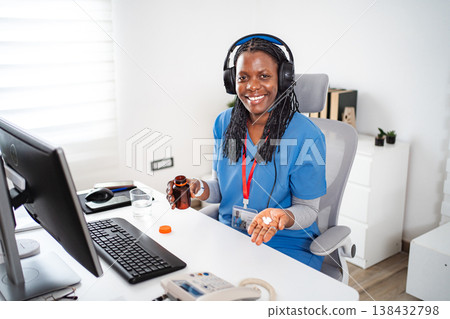 Female healthcare worker offering virtual support while holding medication Female healthcare worker offering virtual support while holding medication 138432798