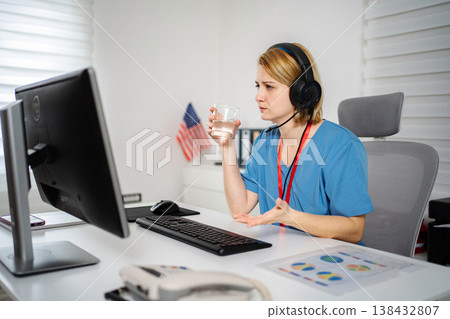 Female nurse wearing headset working from home office Female nurse wearing headset working from home office 138432807