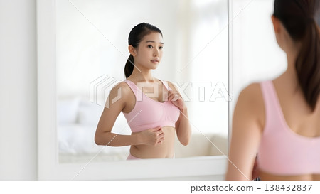 清晨，一位女士對著鏡子微笑，穿上她最喜歡的內衣。 138432837