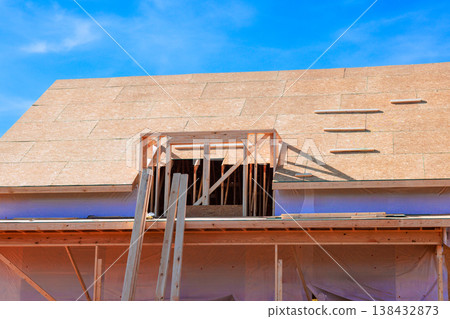 Workers are building trusses roof for new structure with window opening beams framed for later installation. 138432873