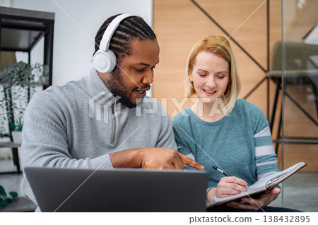 Diverse colleagues collaborating on project, man pointing at laptop 138432895