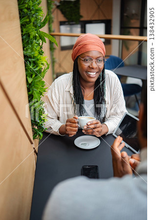 Woman smiling having coffee meeting a man in cafe 138432905