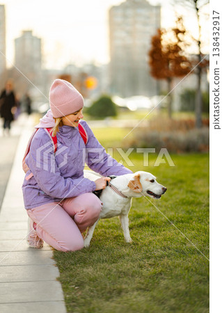 Woman petting dog on leash in city park Woman petting dog on leash in city park 138432917