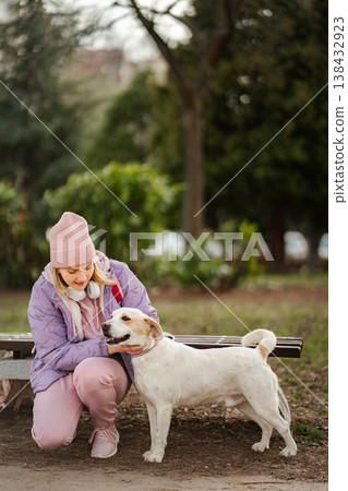 Young woman petting dog in park enjoying companionship Young woman petting dog in park enjoying companionship 138432923